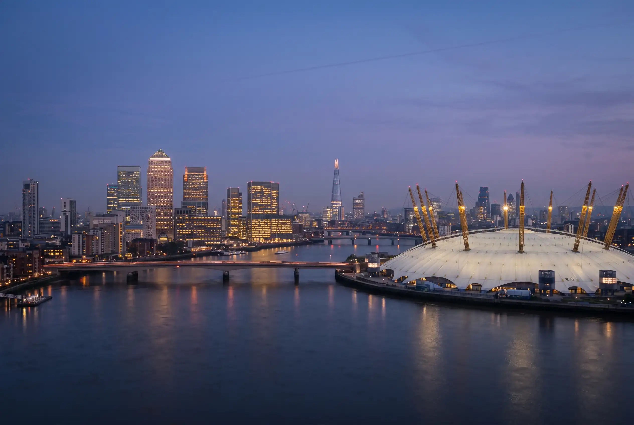 London skyline at dusk with the O2 Arena lit up against the Thames